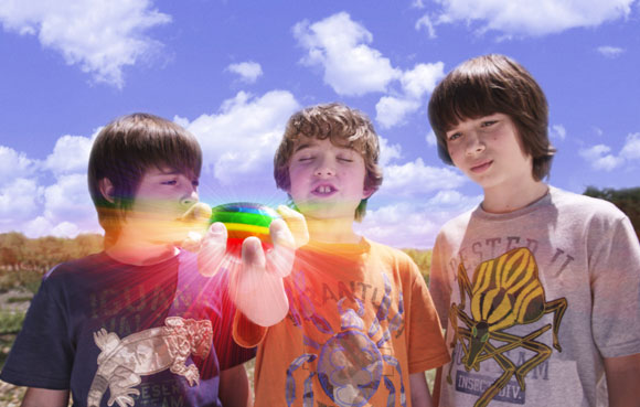 Lug (REBEL RODRIGUEZ, left) and Laser (LEO HOWARD, right) watch as Loogie (TREVOR GAGNON) closes his eyes to make a wish on the Rainbow Rock in Warner Bros. Pictures' magical fantasy adventure "Shorts." Photo courtesy of Warner Bros. Pictures